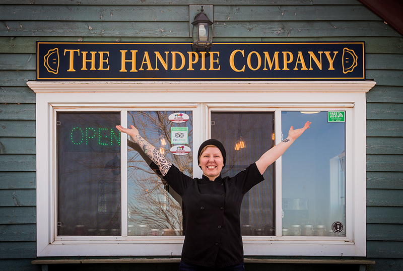 Chef Sarah Bennetto O'Brien shows off the sign for her new business, The Handpie Company