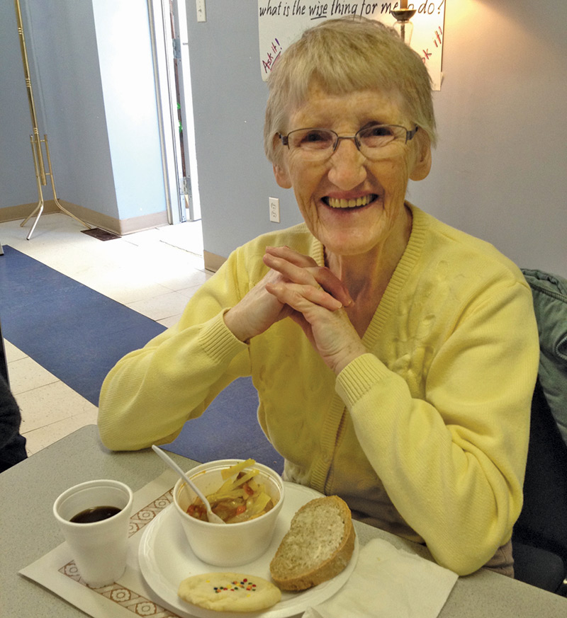 Elderly woman enjoying a bowl of soup and some bread at Soul Soup