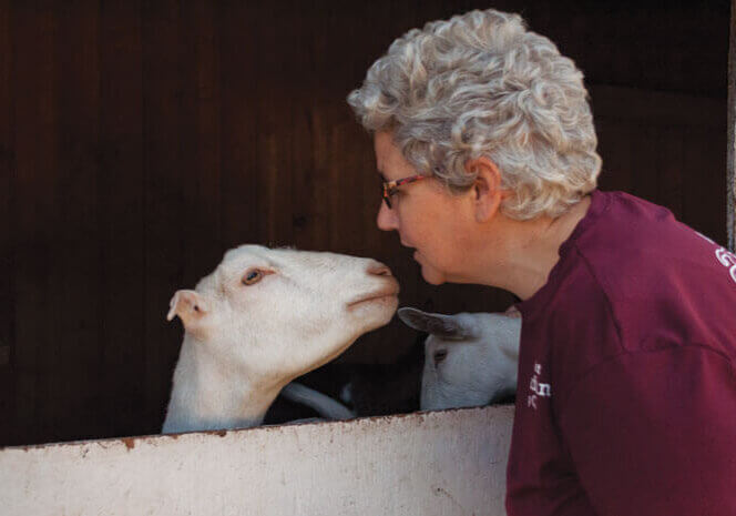Em Zember of Oldfield's Dairy is greeted by one of her goats.//Photo Credit: Laura Weatherbie/Salty