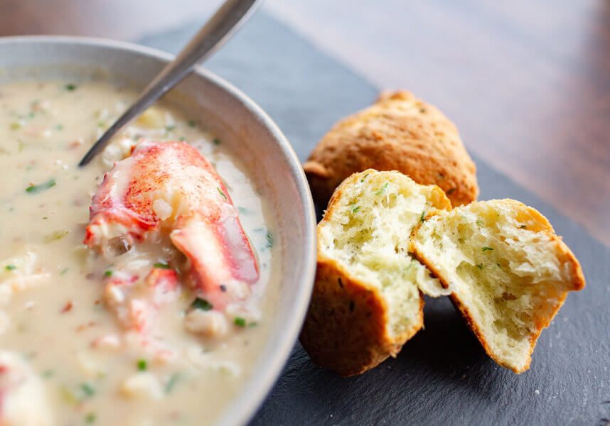 bowl of lobster chowder with cheddar cheese scones