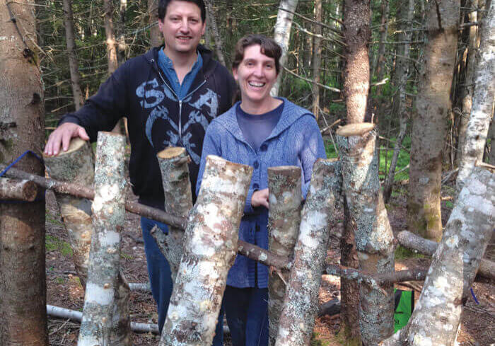 Dale and Julie Hamilton of Borden with their maple logs, inoculated with shiitake mushroom mycelium. //Photo Credit: Katherine Bell
